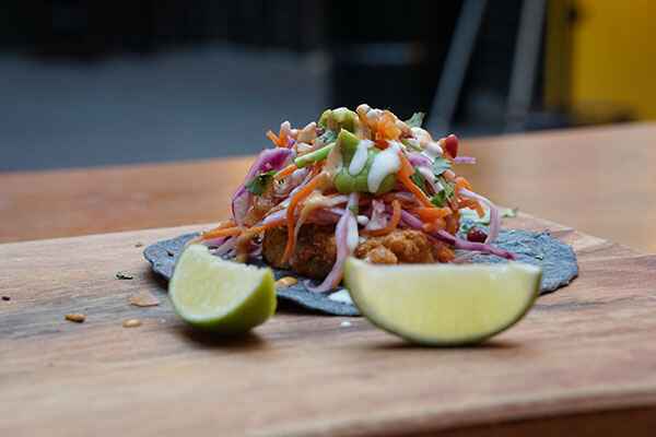 Picture of street tacos with a slice of lime in front of it